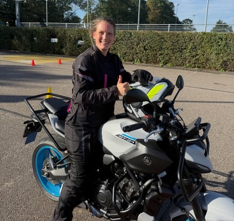 Student in motorbike gear giving a thumbs-up on the Yamaha MT-07 at the practice ground