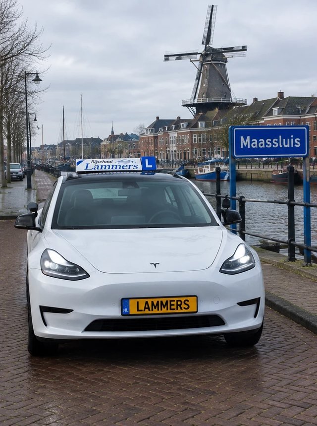 De witte Tesla van Rijschool Lammers aan de haven met de molen in Maassluis
