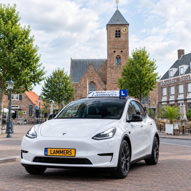 De witte Tesla Model Y van Rijschool Lammers voor de kerk met de gouden klok in Naaldwijk